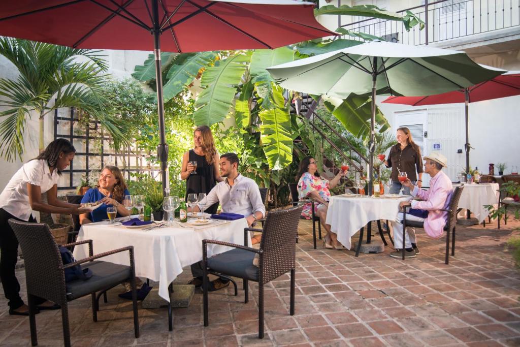 un gruppo di persone seduti a tavoli con ombrelloni di Hotel Boutique Casa Sánchez a Santo Domingo