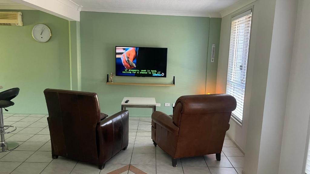 a living room with two chairs and a flat screen tv at BNE24M1 in Slacks Creek