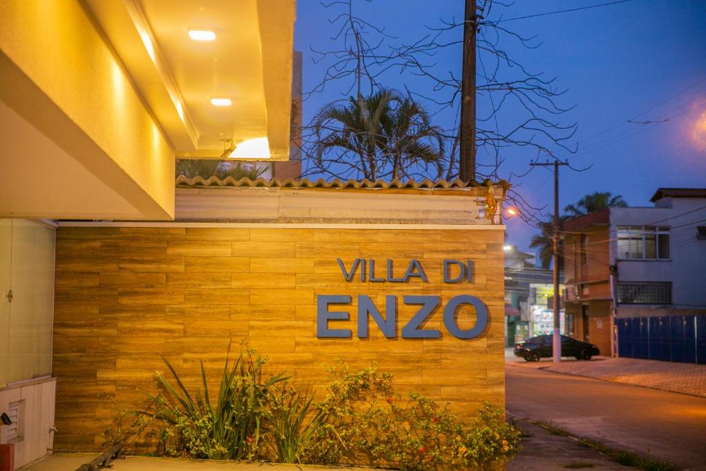 un panneau sur le côté d'un bâtiment avec le mot villa enzo dans l'établissement Pousada Villa Di Enzo, à Ubatuba