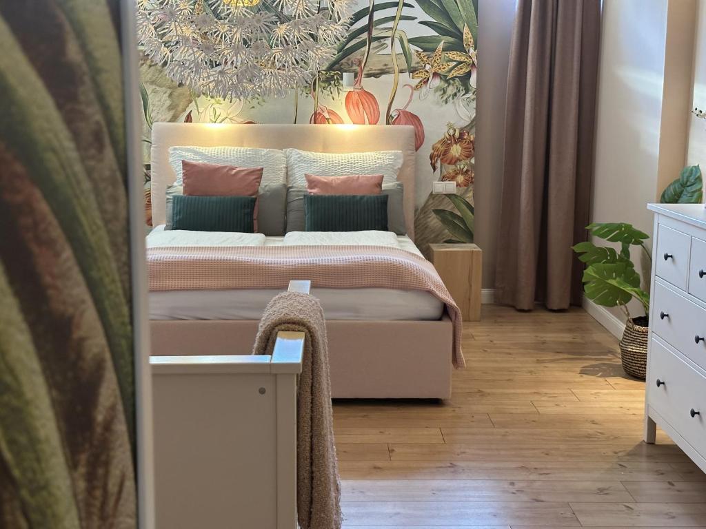 um quarto com uma cama com almofadas rosa e verde em Haus am See B&B em Bornheim