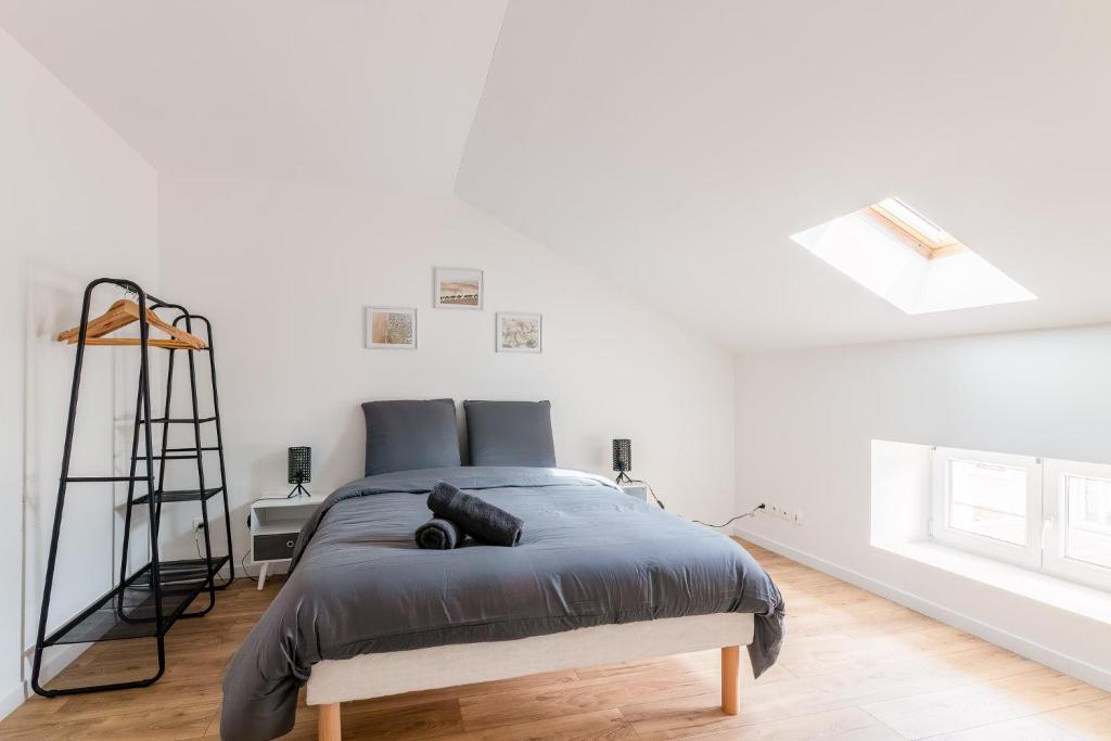 une chambre avec un lit dans une pièce blanche dans l'établissement Le Carnot, à Homécourt