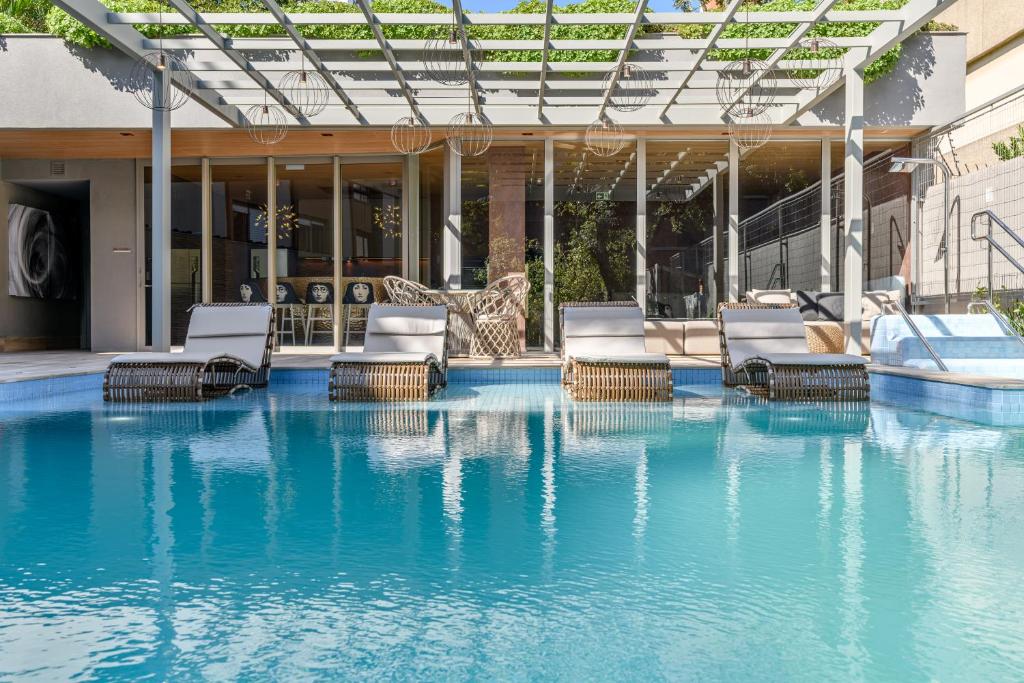 a swimming pool with lounge chairs and a swimming pool at Charlie Porto Alegre Moinhos in Porto Alegre