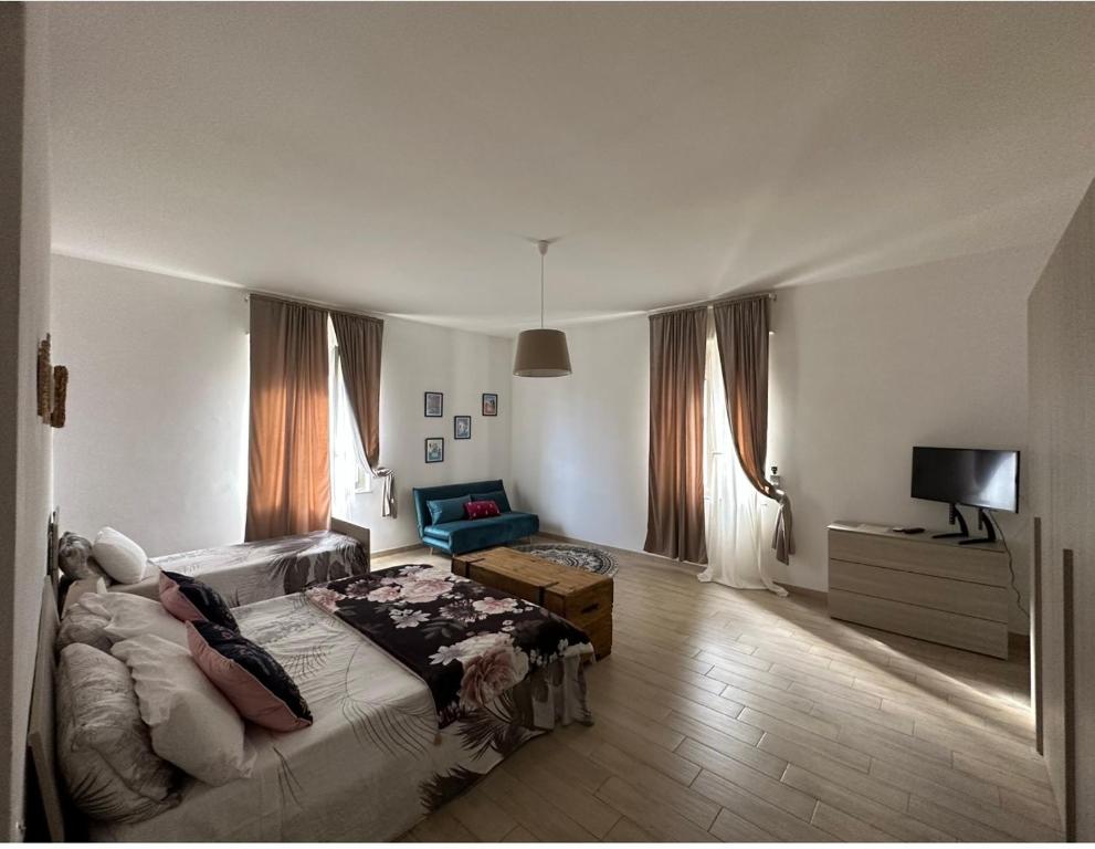 - une chambre avec un lit, un canapé et une télévision dans l'établissement La casa di Sarah aspetta voi, à Naples