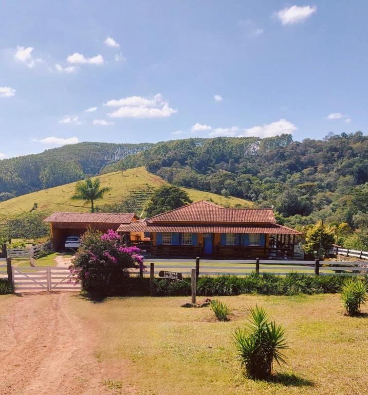 a house on a hill with a dirt road in front at Fazenda do Engenho in Santa Rita do Rio Abaixo