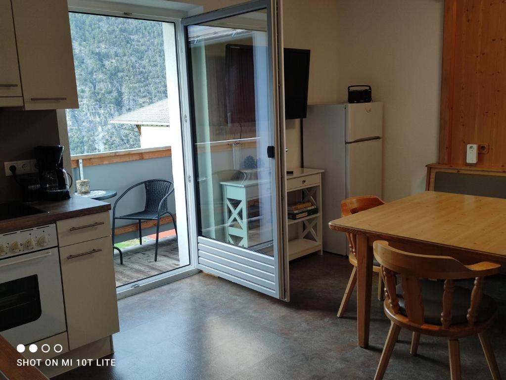 a kitchen with a table and a sliding glass door at groassehof Haus Gstrein in Imsterberg