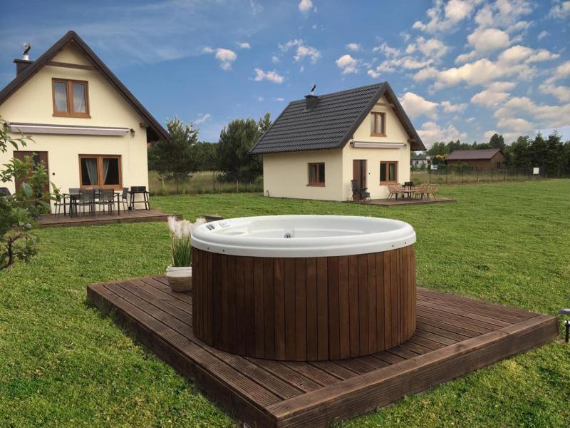 a large tub sitting on a wooden deck in front of a house at Leszczynowe Zacisze in Wiele