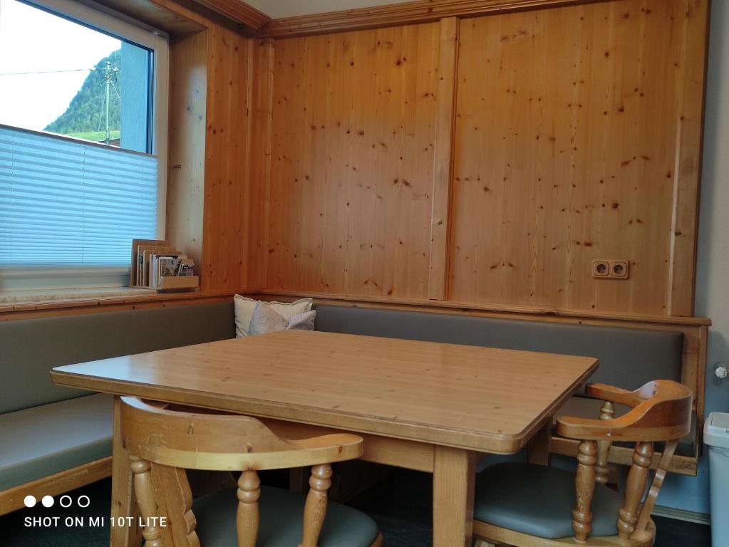 a wooden table and chairs in a room with a window at groassehof Haus Gstrein in Imsterberg