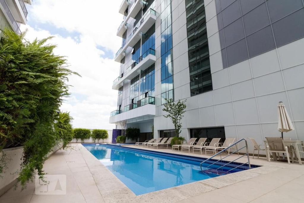 a swimming pool in front of a building at Muito Conforto Selenita1 in Barueri