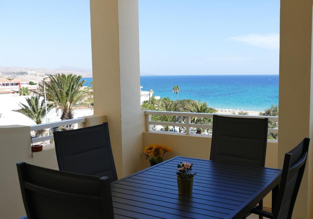 a table with chairs and a view of the beach at Blue Lagoon Apartment in Costa Calma