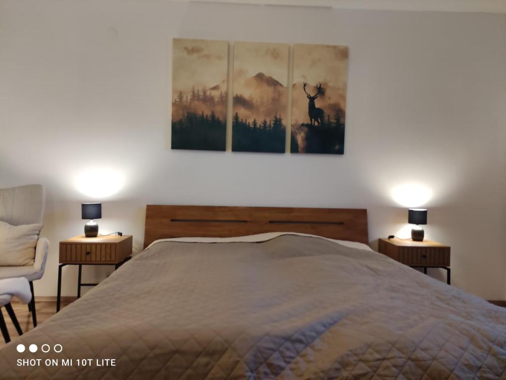 a bedroom with a large bed and two lamps at groassehof Haus Gstrein in Imsterberg