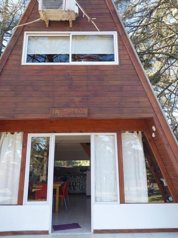 una casa con techo inclinado y puerta blanca en Cabaña alpina Las Lomas en Monte Hermoso