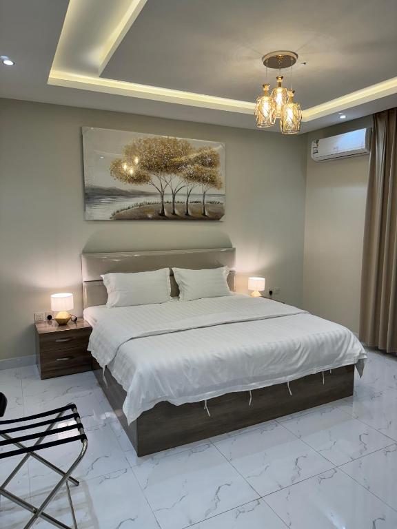 um quarto com uma cama grande e um lustre em فندق بانسي em Abha