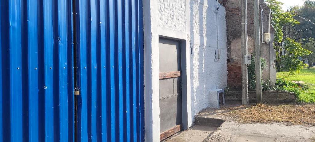 a blue wall next to a building with a door at Apartamento Romian 2 in Paysandú