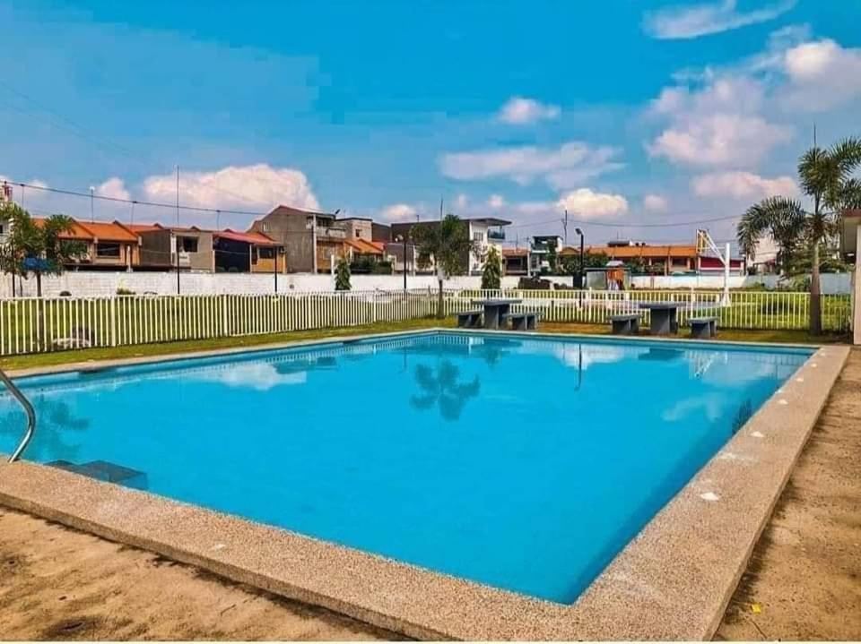 una grande piscina blu con recinzione di Flores Staycation a Marilao