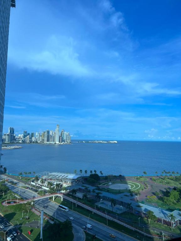 Apartamento con piscina infinita frente al mar en Avenida Balboa PH The Sand في مدينة باناما: اطلالة على المدينة والمحيط من مبنى