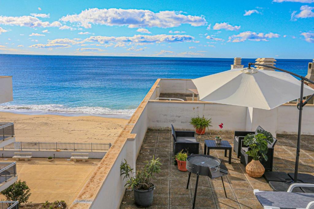 a balcony with an umbrella and the beach at La Riviera Litoral - ONLY FAMILIES in Miami Platja