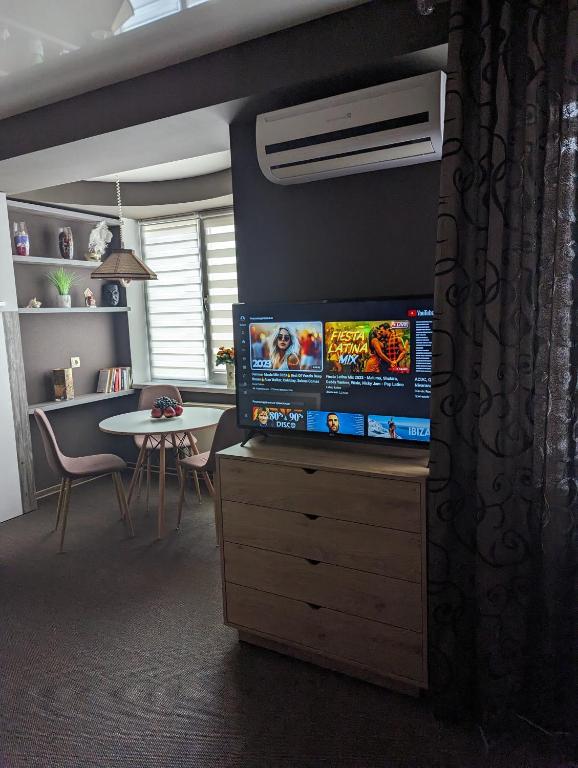 - un salon avec une commode et une télévision à écran plat dans l'établissement CosHOME - apartament, à Chişinău