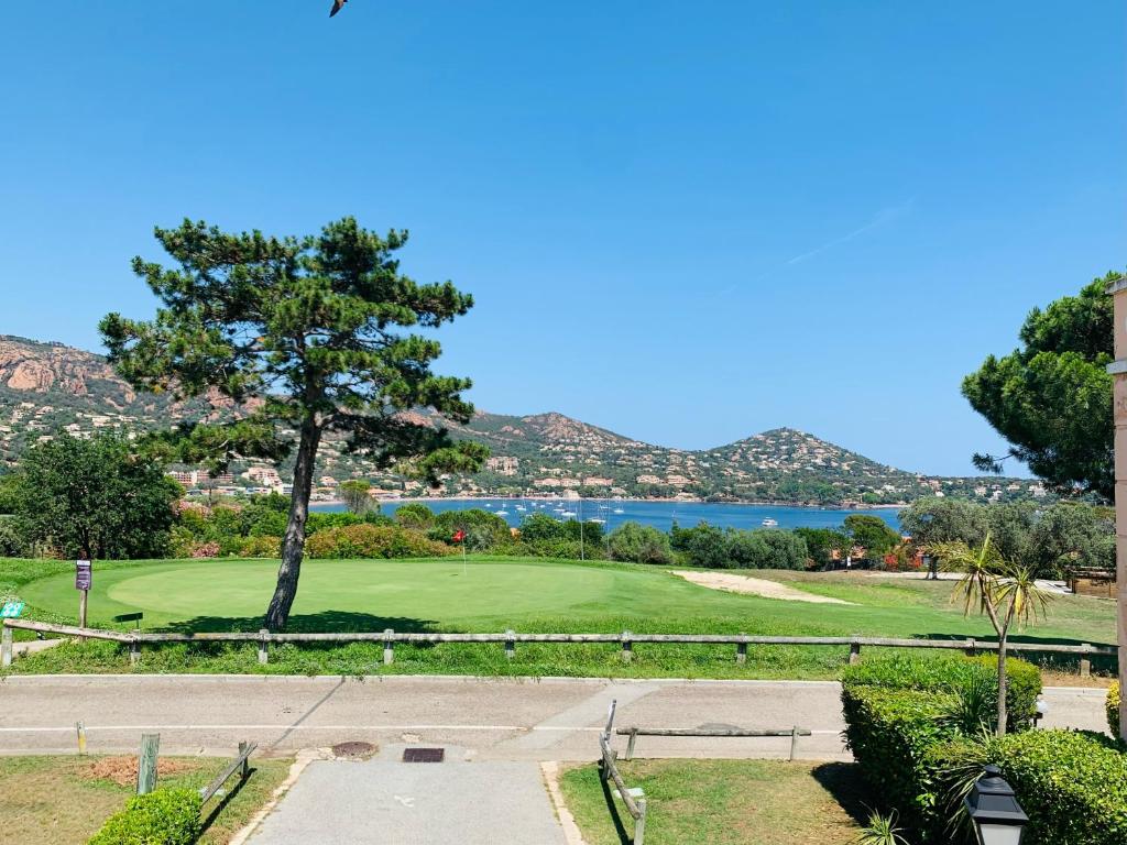 - une vue sur un parcours de golf avec un arbre dans l'établissement Cap Esterel ,Baie d'Agay ,vue mer, à Saint-Raphaël