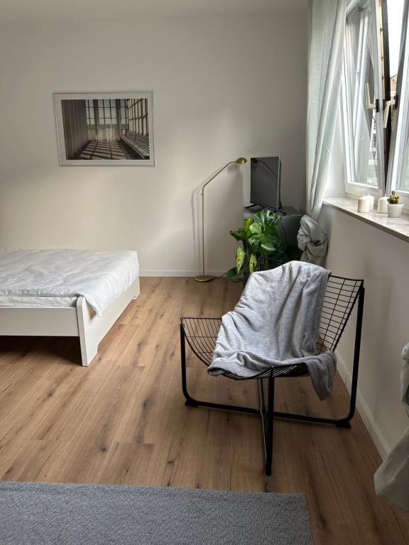 a bedroom with a bed and a chair with a blanket at Kleines und feines Apartment in Zentrum in Mannheim