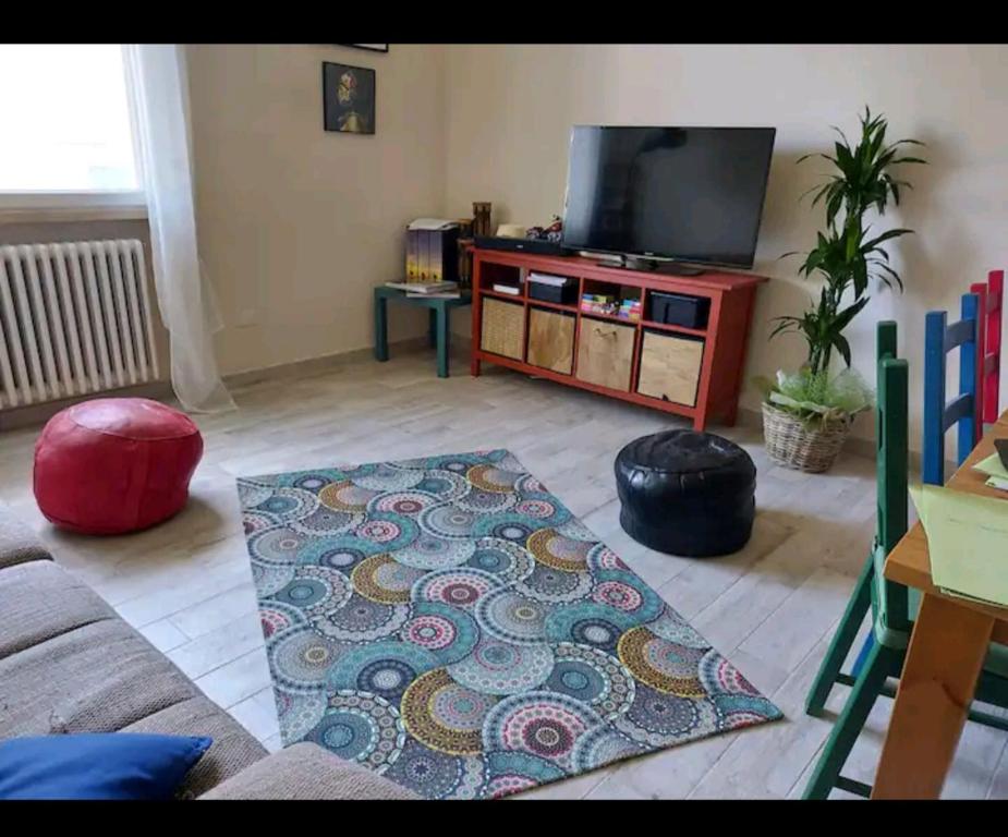 uma sala de estar com uma televisão de ecrã plano e um tapete em Casa Alessandro em Lucca