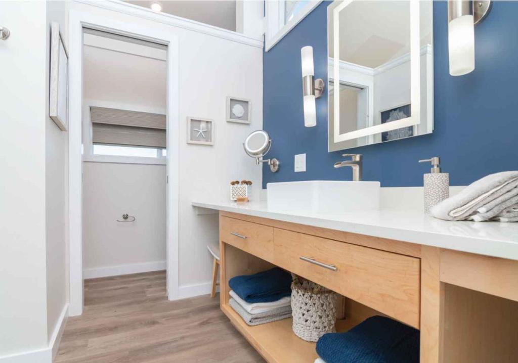 a bathroom with a white sink and a blue wall at Sun Outdoors Sugarloaf Key in Summerland Key