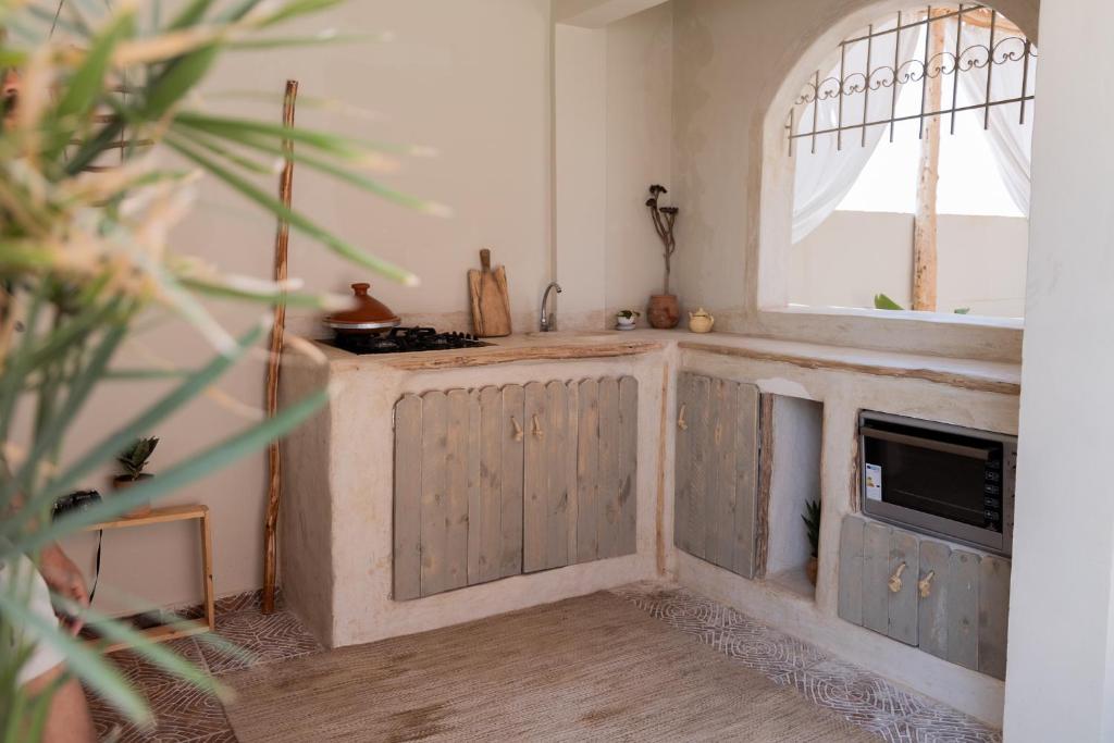 een keuken met een aanrecht met een wastafel en een raam bij DesArt in Tamraght Ouzdar