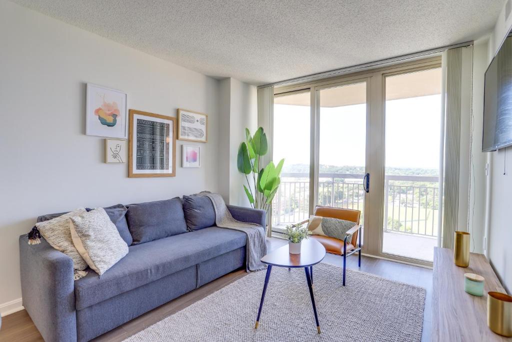 a living room with a blue couch and a table at Spectacular 1 Bedroom Condo At Ballston place With Gym in Arlington