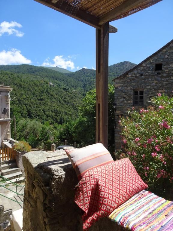 un banco sentado en una roca con vistas a una montaña en Authentique maison de village de Gavignano, 