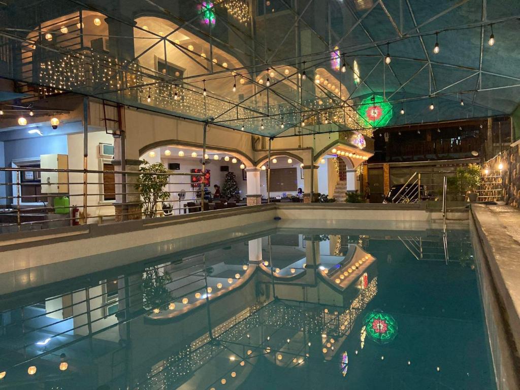 uma piscina com luzes num edifício em villa paguio hot spring resort em Calamba