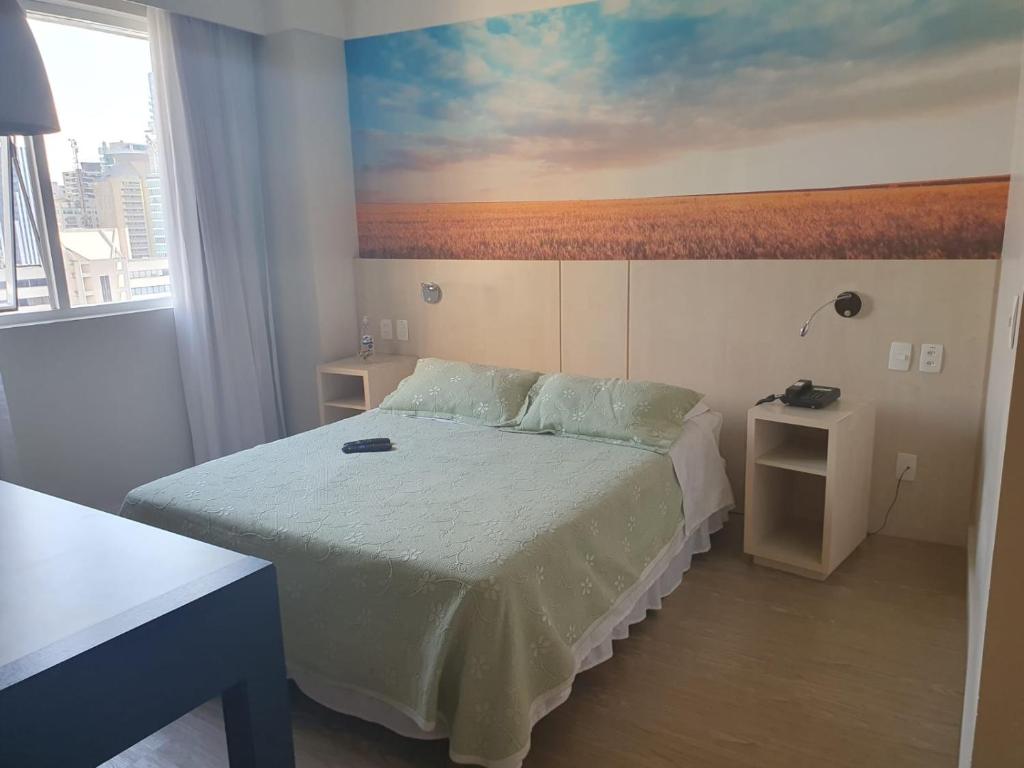 um quarto com uma cama com um quadro na parede em Apto no Comfort Suites COM CAFÉ E ESTAC Incluso em Barueri