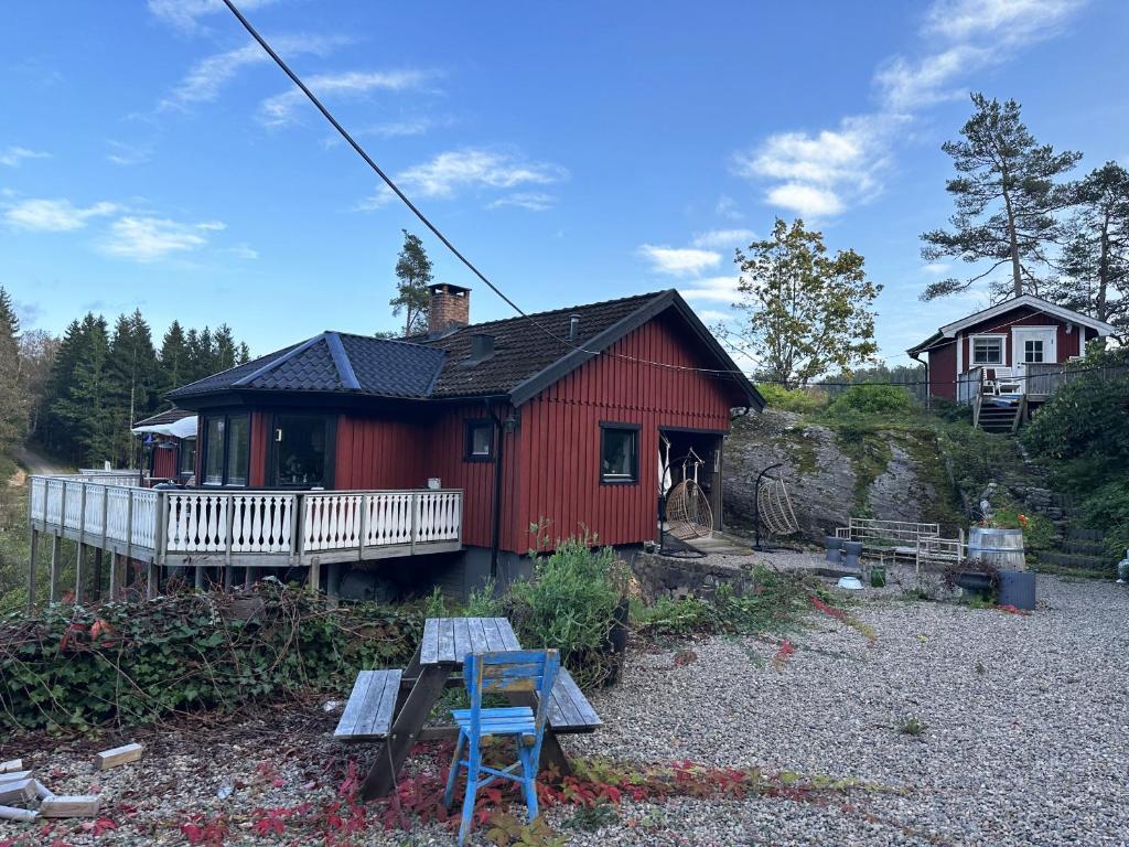 una casa rossa con uno sgabello blu davanti di Very nice villa in northwestern Orust a Henån