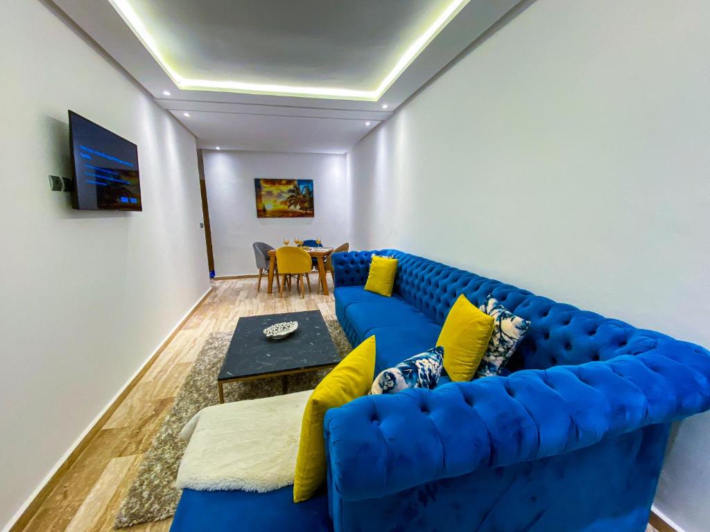 un divano blu in soggiorno con tavolo di Appartement de luxe centre-ville a Rabat