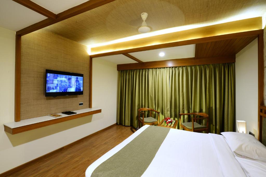 a bedroom with a large bed and a television at Taj Mahal Hotel in Hyderabad