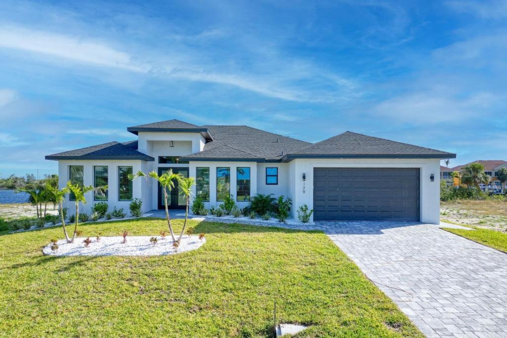 a large white house with a garage at New listing - Amazing new 3beds/3baths Gulf access villa w. heated pool and outdoor kitchen! in Matlacha