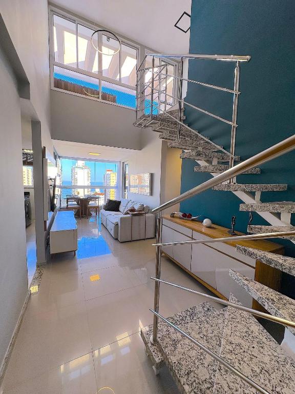 a living room with a spiral staircase in a house at Duplex Penthouse with Jacuzzi and Private BBQ in Itaparica