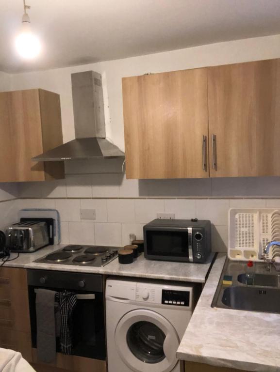 a kitchen with a washing machine and a microwave at Tatia House in Gainsborough