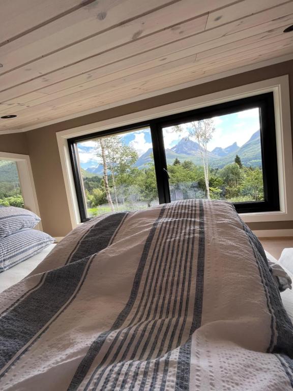 a bed in a room with a large window at Kavliskogen panorama in Isfjorden