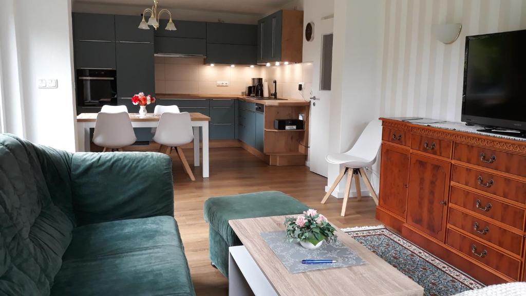 een woonkamer met een bank en een tafel en een keuken bij Ferienwohnungen Liedtke in Behringen