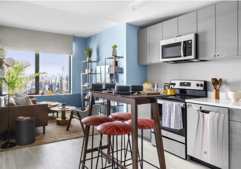 a kitchen with a counter and stools in a room at Glorious 3 Bed 2 Bath In Upper East Side in New York