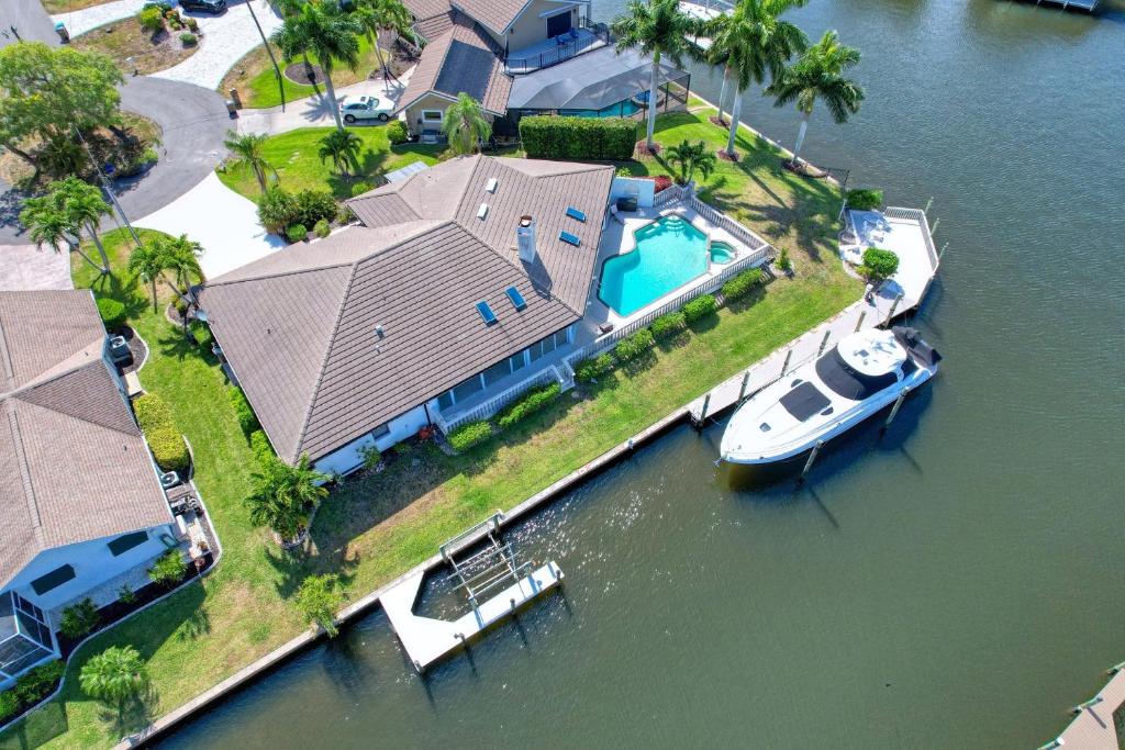 - une vue aérienne sur une maison avec un bateau dans l'eau dans l'établissement Villa Waterview - Amazing Gulf access pool and spa home on spacious corner lot!, à Cape Coral