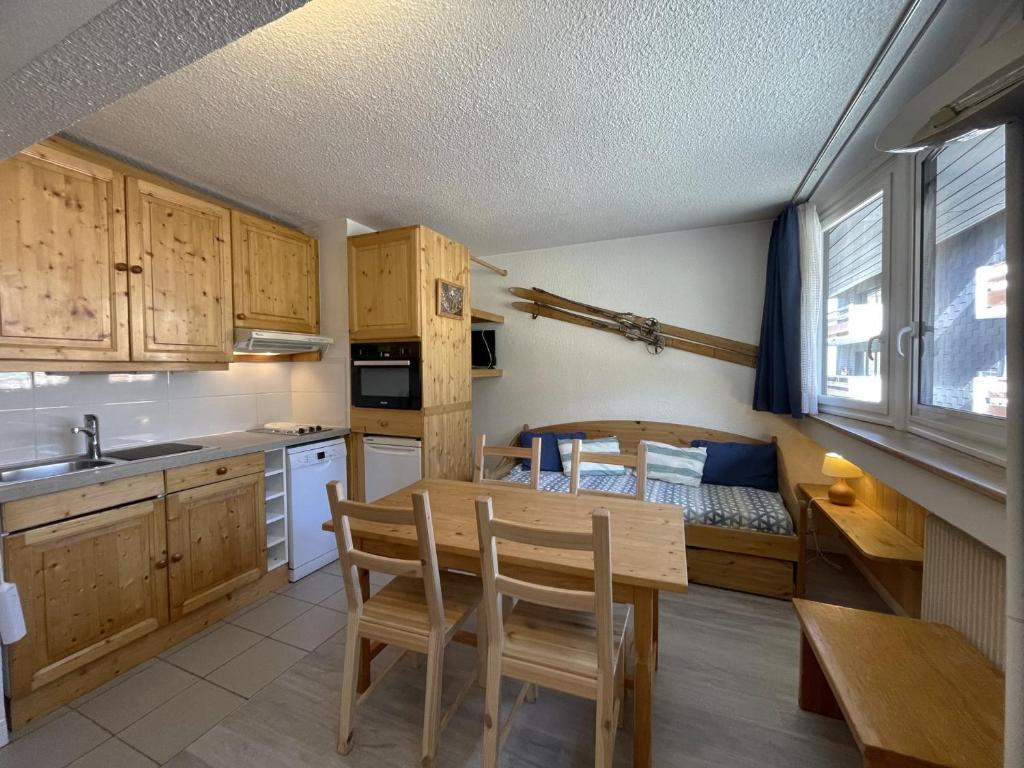 une cuisine et une salle à manger avec une table et un lit dans l'établissement Appartement classique 2 pièces pour 4 personnes aux Menuires - FR-1-452-233, aux Menuires