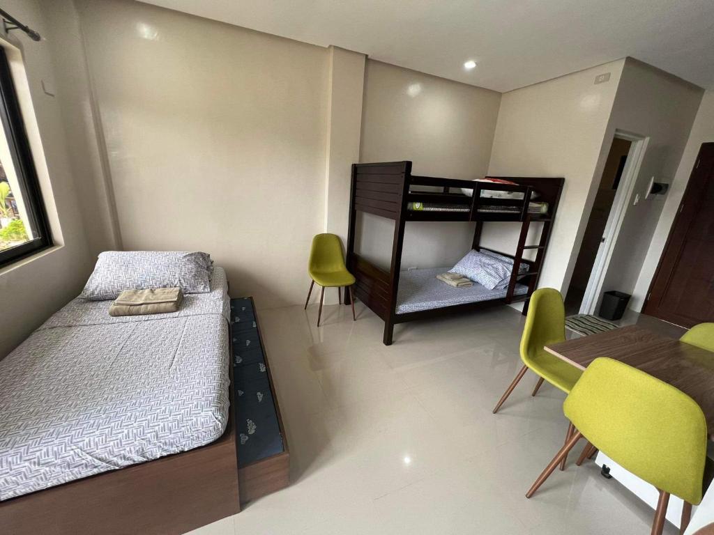 a bedroom with a bunk bed and a table and chairs at Eden’s Residence Space Rental in Cagayan de Oro