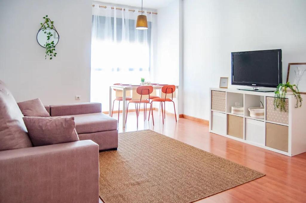 sala de estar con sofá y mesa con sillas en Apartamento Cerca del Mar y aeropuerto, en Alicante