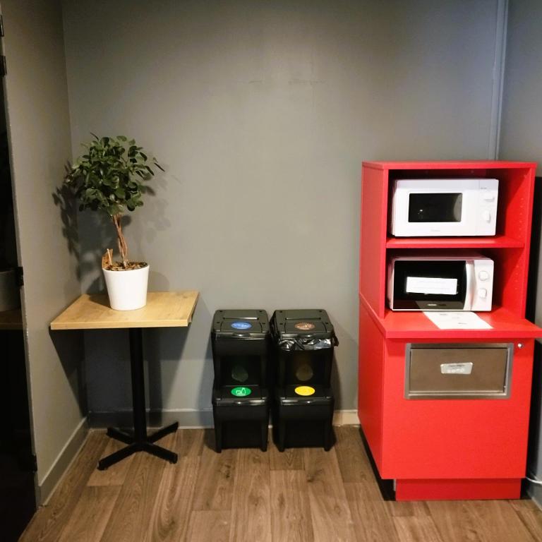 a red lego refrigerator next to a table with a plant at hotelF1 Lyon Bourgoin-Jallieu in LʼIsle-dʼAbeau