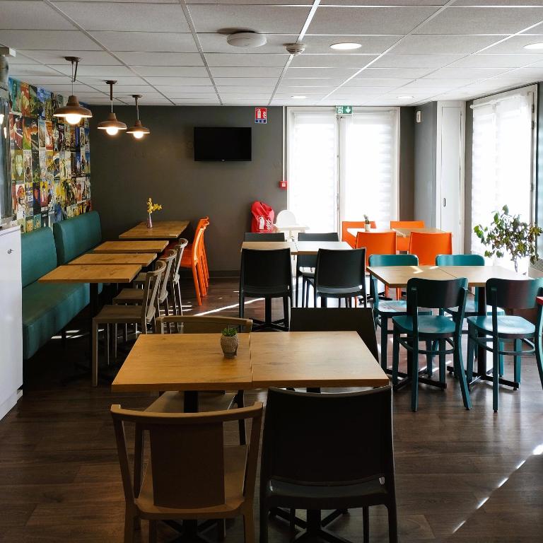 a dining room with wooden tables and chairs at hotelF1 Lyon Bourgoin-Jallieu in LʼIsle-dʼAbeau