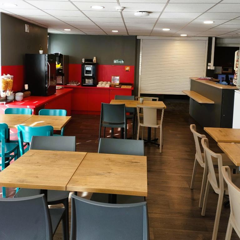 a dining room with wooden tables and chairs at hotelF1 Lyon Bourgoin-Jallieu in LʼIsle-dʼAbeau