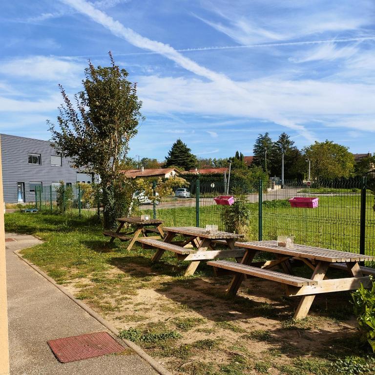a group of wooden picnic tables in a park at hotelF1 Lyon Bourgoin-Jallieu in LʼIsle-dʼAbeau