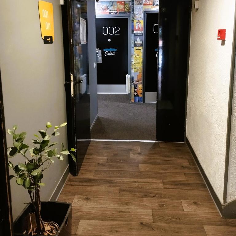 a hallway with wood floors and an open door at hotelF1 Lyon Bourgoin-Jallieu in LʼIsle-dʼAbeau