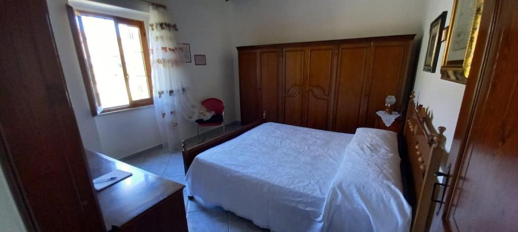 een slaapkamer met een wit bed en een raam bij Casa Bia Mara IUN SU172600 in Villanovaforru