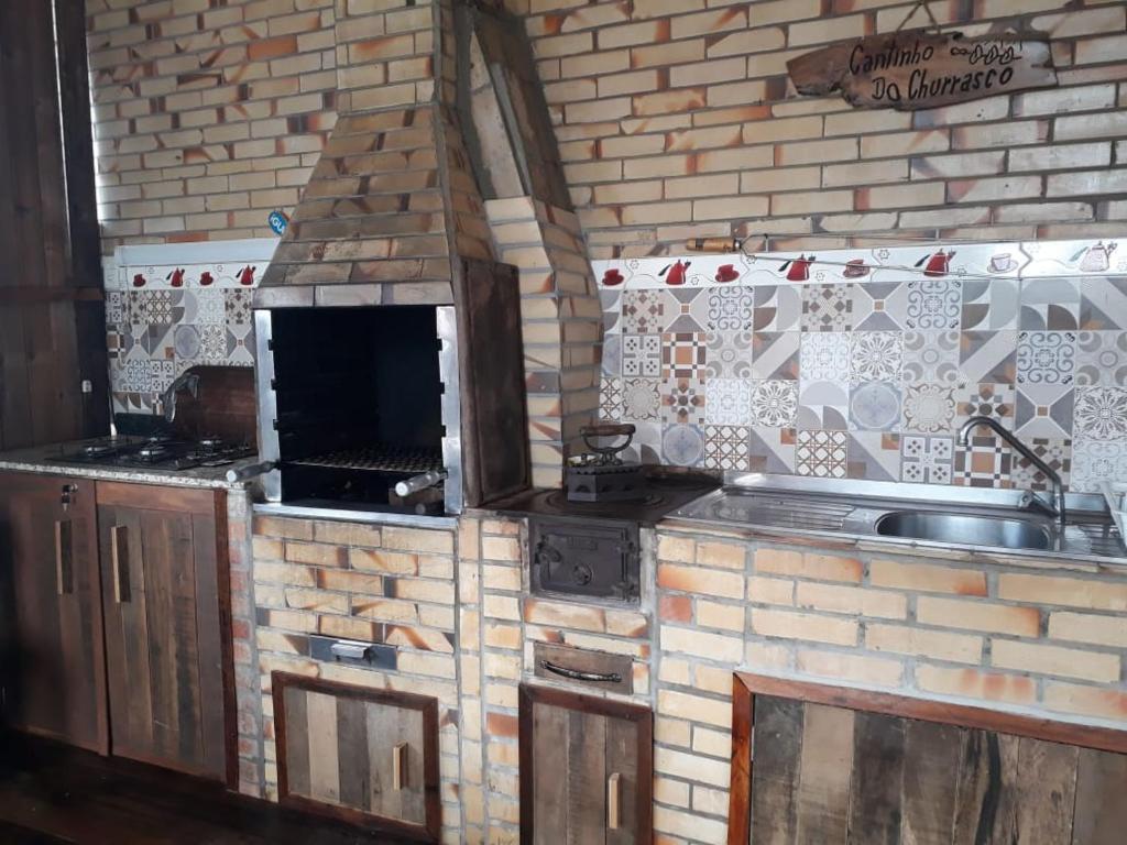 a kitchen with a sink and a brick wall at Casa de ferias in Barra Velha